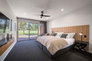 a bedroom with a large bed and a large window at The Villas in Waikerie