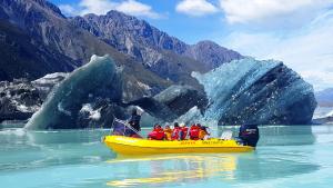 a group of people in a yellow boat in the water at The Hermitage Hotel Mt Cook in Mount Cook Village