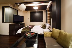 ein Wohnzimmer mit einem Bett und einer Couch in der Unterkunft HOTEL MYTH M -ホテル マイス エム- Adult Only in Sennan + 38 Fotos