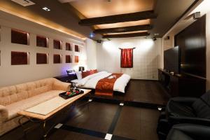 ein Schlafzimmer mit Bett, Sofa und Fernseher in der Unterkunft HOTEL MYTH M -ホテル マイス エム- Adult Only in Sennan