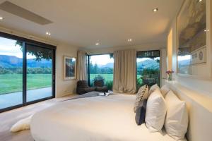 a large bedroom with a large bed and large windows at Alpine Retreat in Queenstown