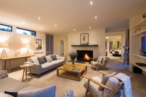 Alpine Retreat في كوينزتاون: غرفة معيشة مع أريكة ومدفأة