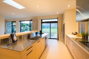 a large kitchen with stainless steel appliances and a large window at Alpine Retreat in Queenstown