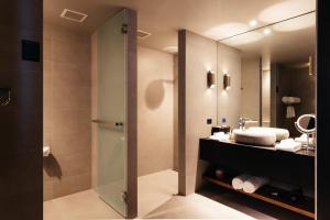 a bathroom with a shower and a sink and a mirror at MACq 01 Hotel in Hobart