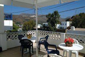 a table and chairs on a balcony with a view at Poseidon Studios in Aegiali +10 photos