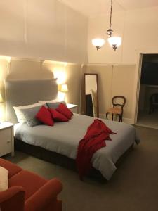 a bedroom with a large bed with red pillows at Dunkeld Old Bakery Accommodations in Dunkeld