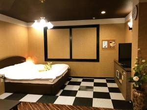 a bedroom with a bed and a checkered floor at Pal Annex Katsuyama (Love Hotel) in Miyakomachi