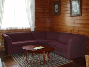 a living room with a purple couch and a table at Boat Harbour Garden Cottages in Boat Harbour