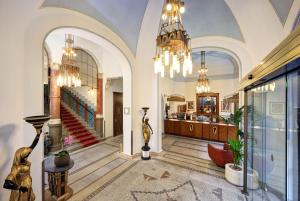 プラハにあるホテル パリ プラハの階段とシャンデリアのある広いロビー