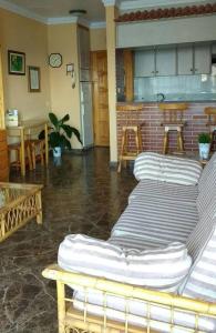 sala de estar con sillas, mesa y cocina en Cozy Apartment en Candelaria