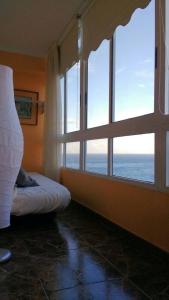 カンデラリアにあるCozy Apartmentの窓と景色を望むベッドが備わる客室です。