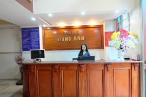 a woman standing at a counter with a laptop at Spring Hung Anh Hotel in Ho Chi Minh City