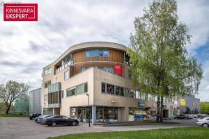 a building with cars parked in a parking lot at Cozy beach apartment in Pärnu
