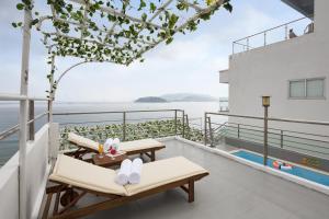 balcón con sillas y vistas al agua en Blue Pearl Hotel, en Nha Trang