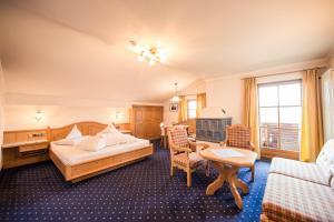 カステルロットにあるParc Hotel Tyrolのベッド、テーブル、椅子が備わるホテルルームです。