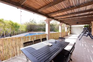 een patio met een tafel en stoelen en een zwembad bij Flintstone Guest House in Eilat