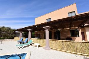 a patio with two chairs and a house at Flintstone Guest House in Eilat