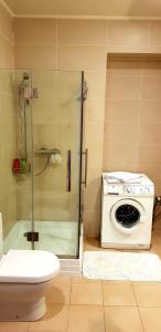 y baño con ducha y lavadora. en Exceptional Uzupis Bridge 3 bedroom apartment, en Vilna