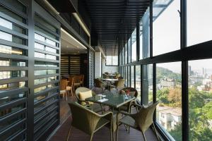 a balcony with a table and chairs and windows at Asia Pacific Hotel Beitou in Taipei