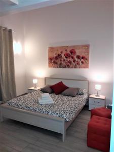 デセンツァーノ・デル・ガルダにあるVillaggio Esmeraのベッドルーム1室(ベッド1台付)が備わります。壁には絵画が飾られています。