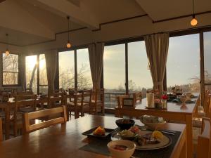a dining room with a table with food on it at 久住高原 赤川温泉スパージュ-Spaju in Taketa