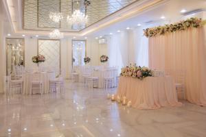 ナロ・フォミンスクにあるKupets Hotelの白いテーブルと椅子、花の飾られた宴会場