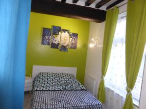 a small bedroom with a bed and a yellow wall at Appartement Bayeux in Bayeux