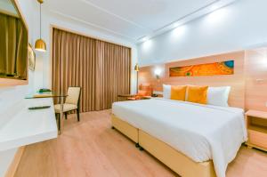 贾姆穆Lemon Tree Hotel Jammu的配有一张大床和一张书桌的酒店房间