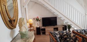 a living room with a couch and a television at Appartement Patarin Dijon in Dijon
