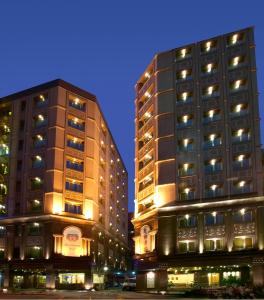 two tall buildings next to each other at night at Royal Seasons Hotel Taipei ‧ Nanjing W. in Taipei