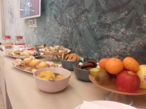 une table recouverte de bols de fruits et autres denrées alimentaires dans l'établissement Centro Città Luxury B&B, à Foggia
