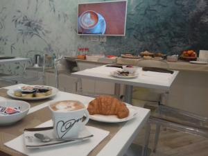 una mesa con una taza de café y un cruasán en Centro Città Luxury B&B, en Foggia