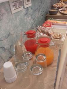 una mesa con jarras y vasos de zumo en un mostrador en Centro Città Luxury B&B, en Foggia