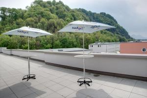 dos sombrillas blancas sentadas en la azotea en MEININGER Hotel Salzburg City Center, en Salzburgo