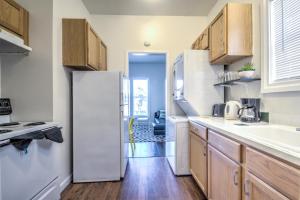 La cuisine est équipée d'un réfrigérateur blanc et de placards en bois. dans l'établissement Renovated Bright 1 BR in the heart of Capitol Hill – APT B, à Seattle