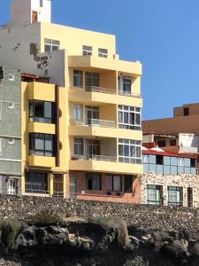een geel gebouw aan de zijkant van een gebouw bij Apartamento en primera línea playa in La Garita