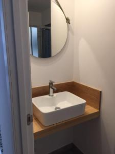 een badkamer met een witte wastafel en een spiegel bij Apartamento en primera línea playa in La Garita