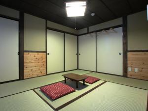 a room with a table and red mats in it at Guest House Yanagiya in Ena