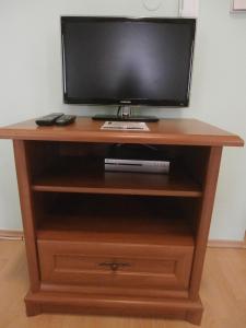 a television on top of a wooden entertainment center at Penzion Scarlet in Trenčín