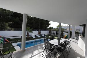 a balcony with a table and chairs and a swimming pool at Can Pastilla II in Can Pastilla