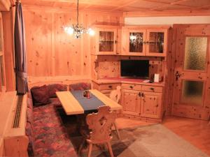 comedor con mesa y TV en una cabaña en Landhaus Winkl, en Ischgl