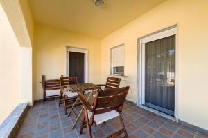 a porch with a table and chairs and a window at Sithonia Lodge in Metamorfosi