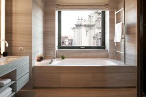 a bathroom with a large bath tub with a window at Armani Hotel Milano in Milan