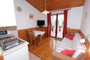 a kitchen and living room with a couch and a table at Guest House Aurora in Rovinj