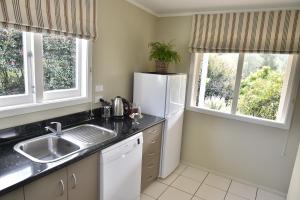 a kitchen with a sink and a refrigerator at Bradleys Garden Bed and Breakfast in Taumarunui