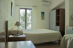 una camera da letto con un letto grande e una finestra di Verdeblu Country Hotel a San Giovanni a Piro