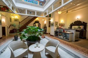 a lobby with chairs and a table and a staircase at Nam Keng Hotel Penang in George Town