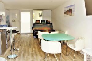 een kamer met een tafel en stoelen en een bed bij La cabine de plage in Batz-sur-Mer