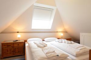 ヴェスターラントにあるWohnung-Amsel-App-4のベッドルーム1室(ベッド2台、天窓付)