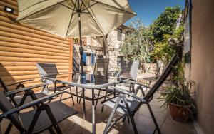 einen Tisch und Stühle mit Sonnenschirm auf einer Terrasse in der Unterkunft Myrtle the Turtle Guesthouse in Safed